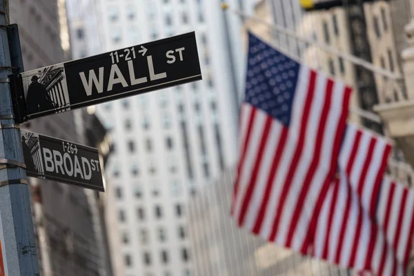 Cartel de Wall Street en Nueva York con banderas estadounidenses y fondo de la Bolsa de Nueva York . — Foto de Stock