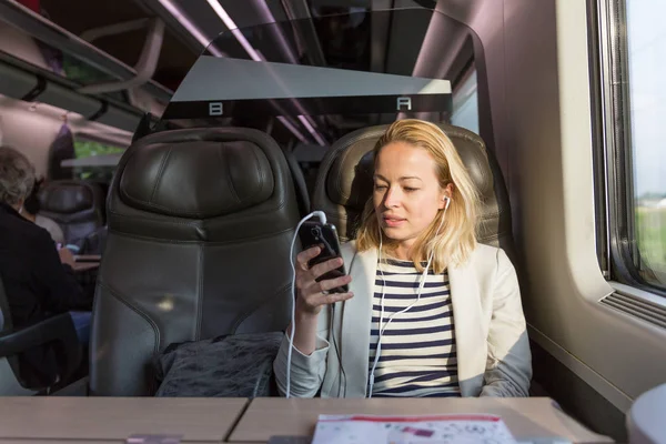 İş kadını trenle seyahat ederken cep telefonuyla iletişim kuruyor.. — Stok fotoğraf