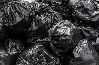 Siyah atık plastik depo gözü çanta arka plan yığını.