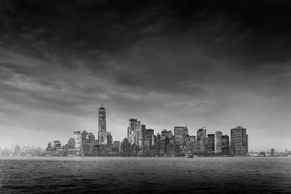 Dramatic panoramic view of storm over Lower Manhattan from Ellis Island at dusk, New York City. Black and white image.