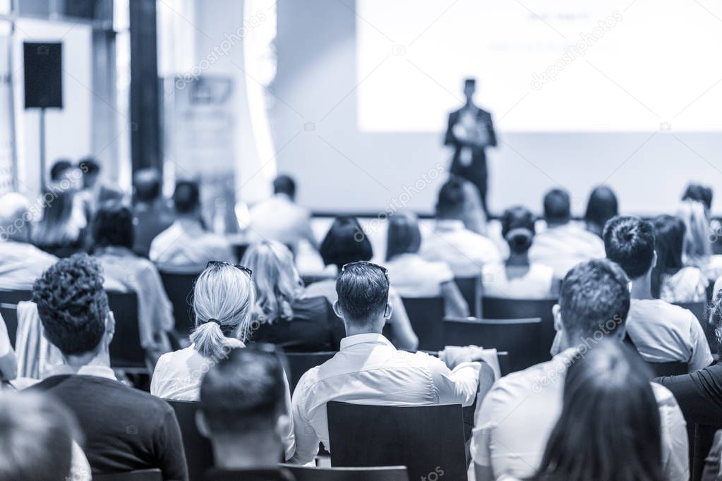 Business speaker giving a talk at business conference event.