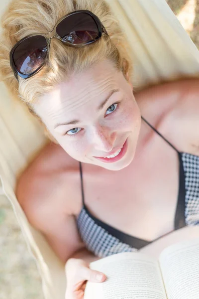 Frau liest Buch in Hängematte am Strand — Stockfoto