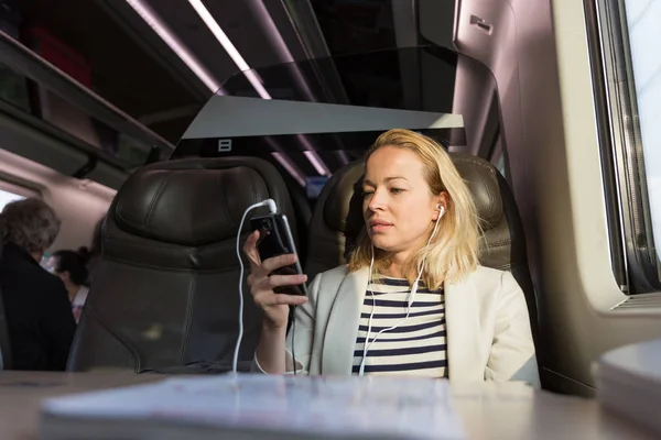 Femme d'affaires communiquant sur un téléphone portable pendant un voyage en train. — Photo