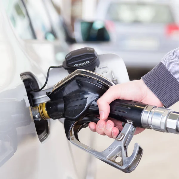 Närbild av mans handpumpning bensin bränsle i bilen på macken. — Stockfoto