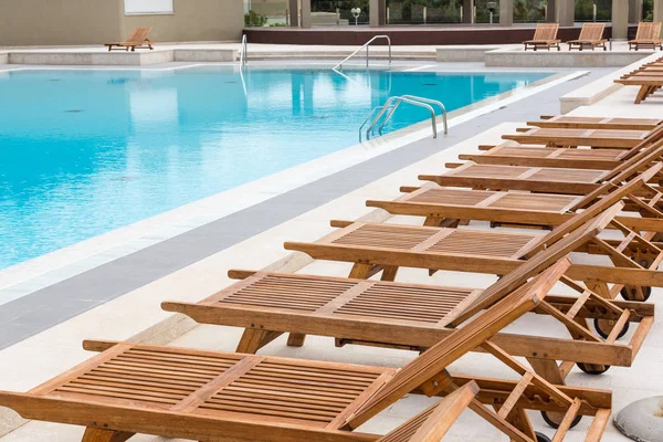 Piscina de luxo com espreguiçadeiras de madeira . — Fotografia de Stock