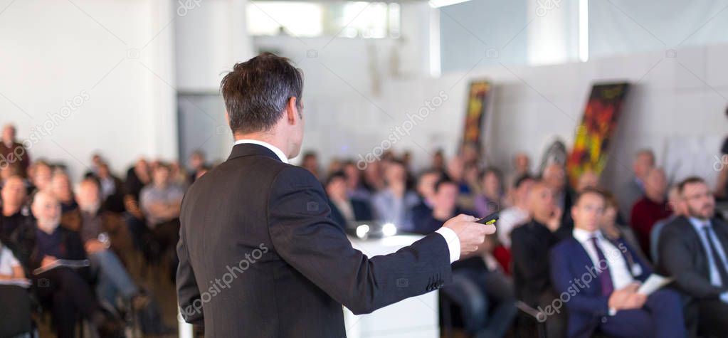 Public speaker giving talk at Business Event.