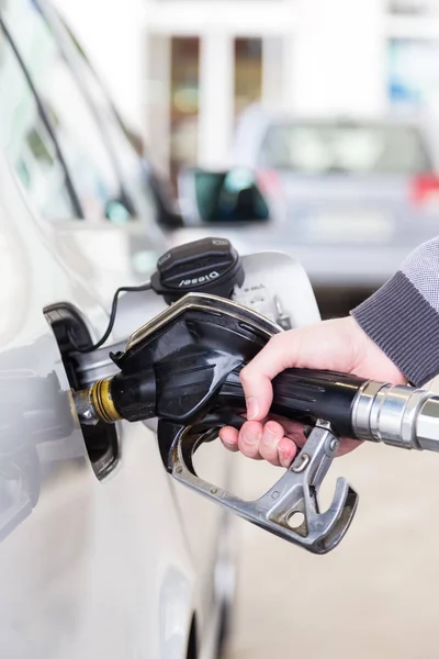 Closeup of mans hand pumping gasoline fuel in car at gas station. — Stock Photo, Image