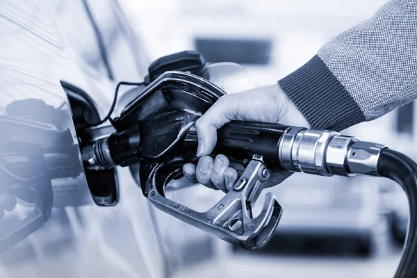 Fechar-se dos homens mão bombeamento gasolina combustível no carro no posto de gasolina . — Fotografia de Stock