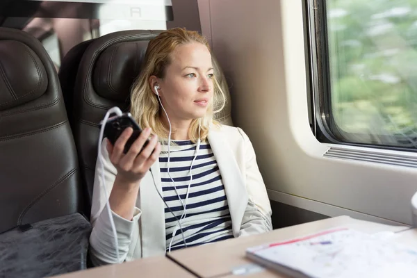 Geschäftsfrau kommuniziert auf Bahnreise per Handy. — Stockfoto