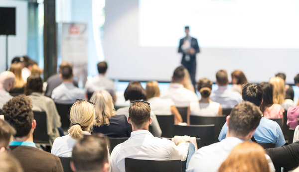 Деловой докладчик выступает на мероприятии бизнес-конференции.