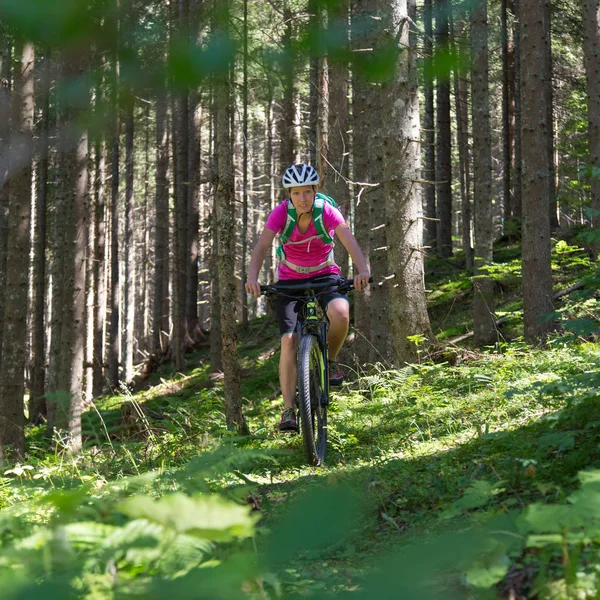 Active sporty woman riding mountain bike on forest trail . — Stock Photo, Image