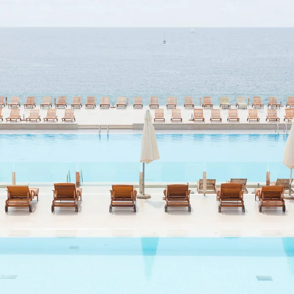 Piscina de luxo com espreguiçadeiras de madeira . — Fotografia de Stock