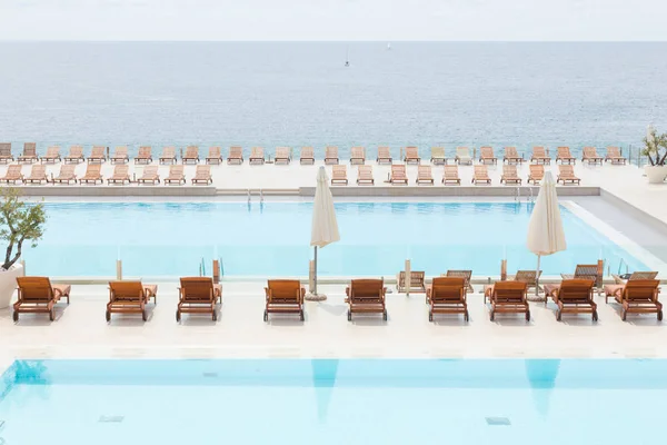 Piscina de luxo com espreguiçadeiras de madeira . — Fotografia de Stock