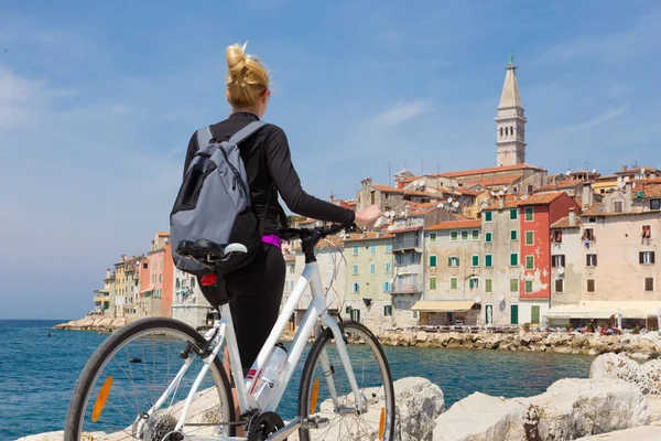 Jovem ativa ciclismo turístico feminino e desfrutando de bela vista de Rovinj, Ístria, Croácia . — Fotografia de Stock