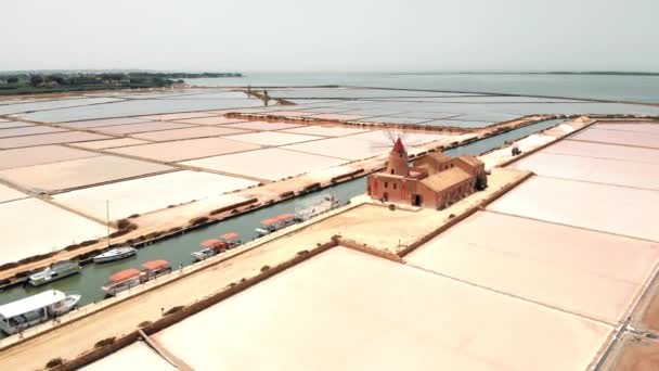 Aerial of salt pans showing different colored pans and old windmill of the Riserva Naturale Saline Di Trapani salt museum. — Stock Video