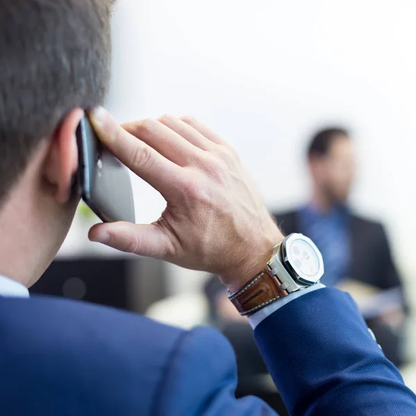 Corporate business team at business meeting and manager talking on phone.