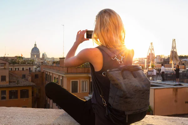 Женщина-туристка фотографирует с мобильного телефона площадь Пьяцца ди Spagna, знаменательную площадь с испанскими ступеньками в Риме, Италия на закате . — стоковое фото