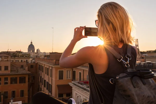Turista feminino tirar fotos de telefone celular da Piazza di Spagna, praça de referência com passos espanhóis em Roma, Itália ao pôr do sol . — Fotografia de Stock