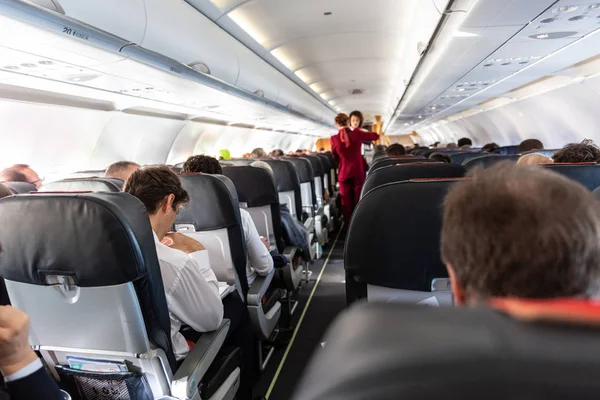 Интерьер коммерческого самолета с пассажирами на своих местах во время полета . — стоковое фото