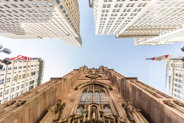 Amplo ângulo vista para cima da Igreja Trinity na Broadway e Wall Street com arranha-céus circundantes, Lower Manhattan, Nova York, EUA — Fotografia de Stock