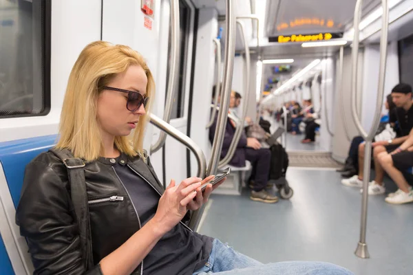 Junges Mädchen liest von Handy-Bildschirm in U-Bahn. — Stockfoto