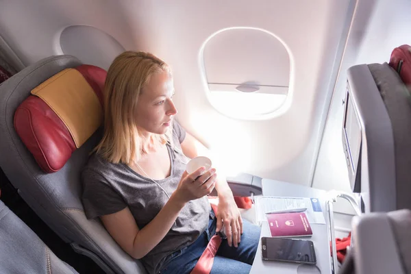 Woman drinking coffee on commercial passengers airplane during flight. — Stock Photo, Image