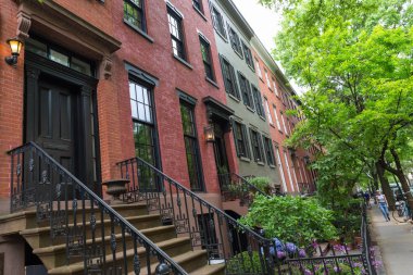 Manhattan, New York City, ABD 'deki Greenwich Village mahallesindeki boş kaldırım bloğu boyunca uzanan eski kumtaşından binalar..