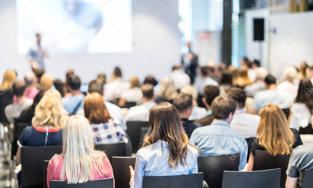 Business speaker giving a talk at business conference event.