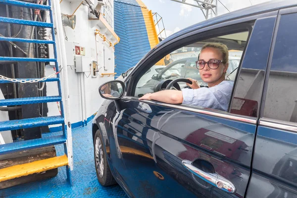 Female driver parking her car on ferry boat on trip to their summer vacations island destination. Sardinia, Italy — Stock Photo, Image