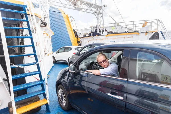 Conductora estacionando su coche en ferry en viaje a su destino de vacaciones de verano isla. Cerdeña, Italia — Foto de Stock