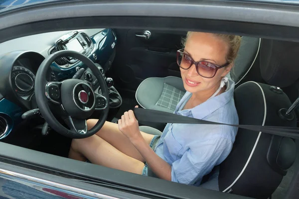 Segurança primeiro. Linda loira caucasiana senhora fixando cinto de segurança do carro . — Fotografia de Stock