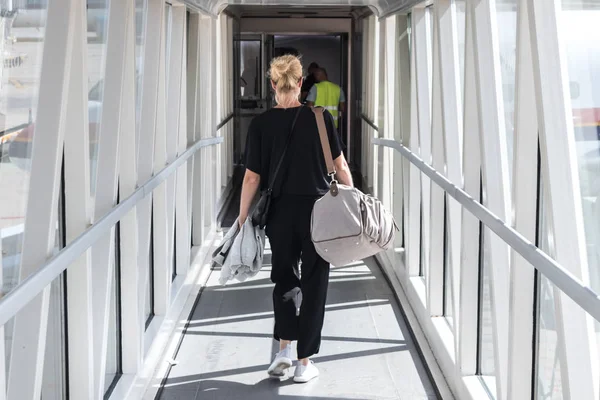 Kobiece pasażera torba bagaż podręczny, chodzenie z samolotu na pokład korytarza. — Zdjęcie stockowe