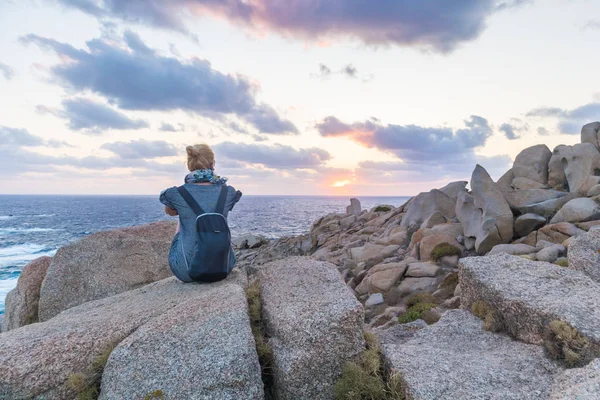 Jóvenes viajeras solas observan una hermosa puesta de sol en espectaculares rocas de Capo Testa, Cerdeña, Italia . —  Fotos de Stock