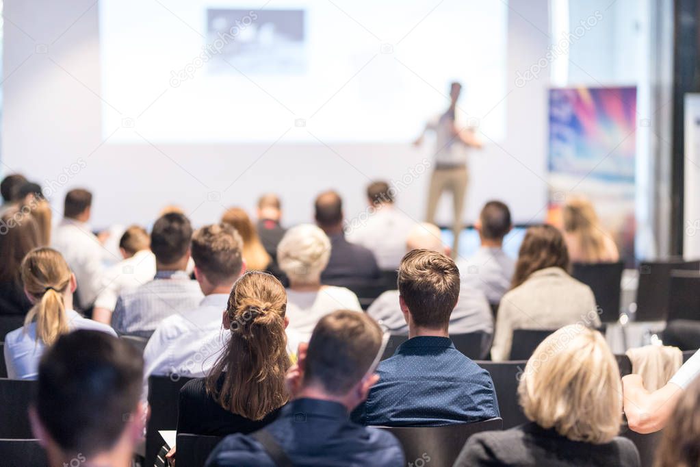 Business speaker giving a talk at business conference event.