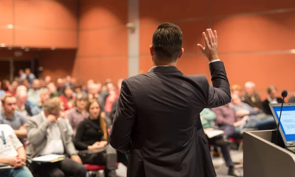 Public speaker giving talk at Business Event.