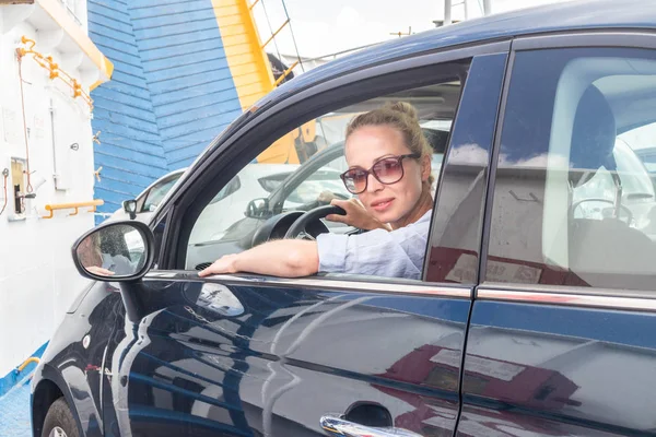 Женщина-водитель паркует свою машину на пароме во время поездки к месту назначения летнего отдыха на острове. Фелиния, Италия — стоковое фото