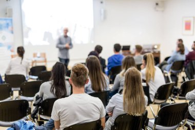 Profesör Üniversitesi'nde konferans salonunda ders.