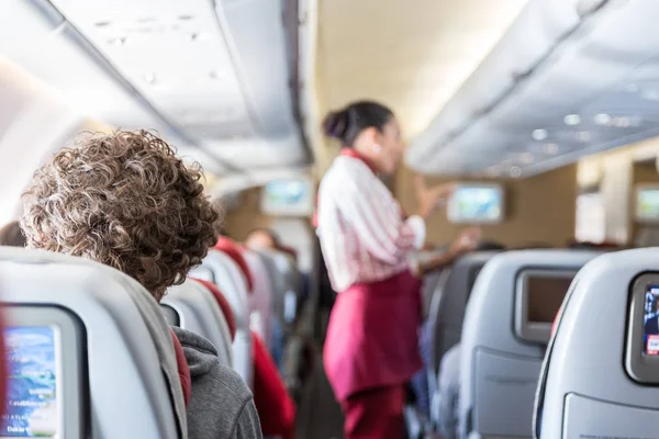 Interiör av kommersiella flygplan med passagerare på sina platser under flygning. — Stockfoto