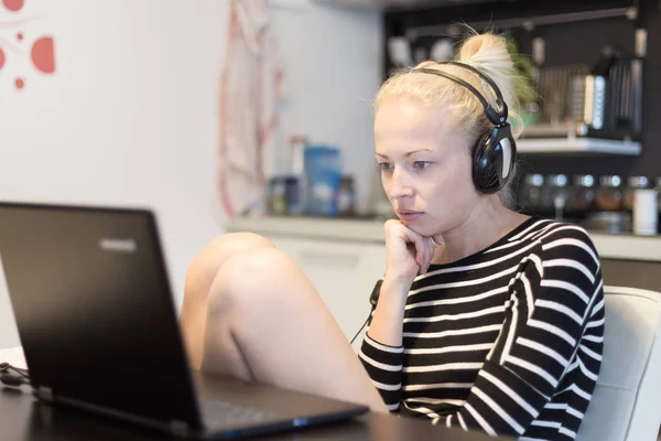 Femme adulte dans ses vêtements décontractés à la maison travaillant et étudiant à distance de son petit appartement tard dans la nuit . — Photo