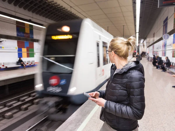 Mujer con un teléfono celular esperando metro . — Foto de Stock