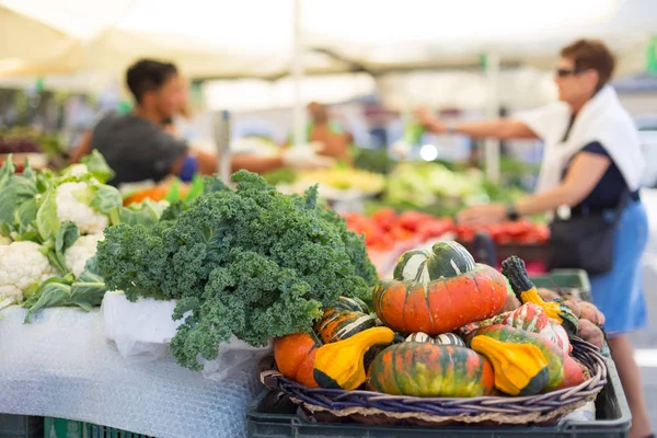 Des personnes floues non recodnisées achetant des légumes cultivés sur le marché fermier avec une variété de légumes biologiques . — Photo