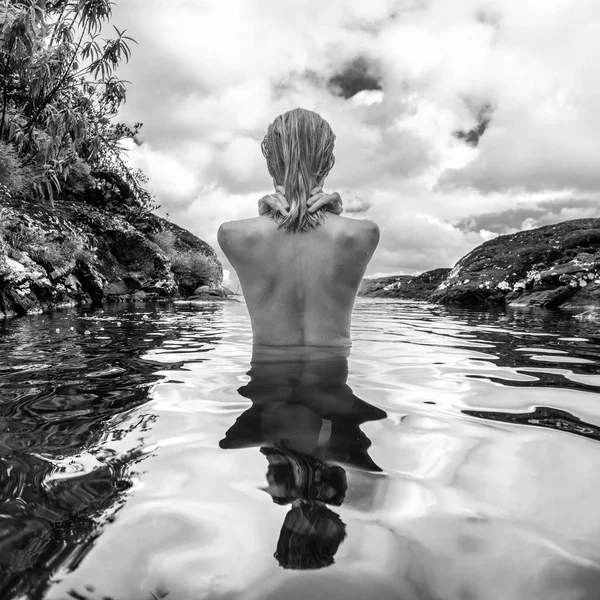 Femme nue se baigner et se détendre dans la piscine naturelle en noir et blanc . — Photo