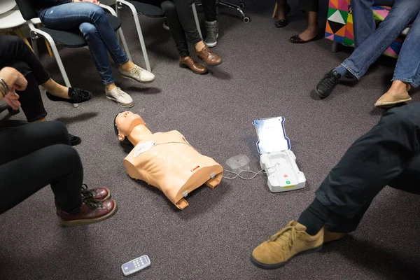 Istruttore che insegna il corso di rianimazione cardiopolmonare di primo soccorso e l'uso di defibrillatore esterno automatizzato nel laboratorio di RCP. — Foto Stock