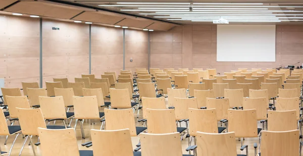 Lege houten stoelen in een collegezaal van cotmporary. — Stockfoto