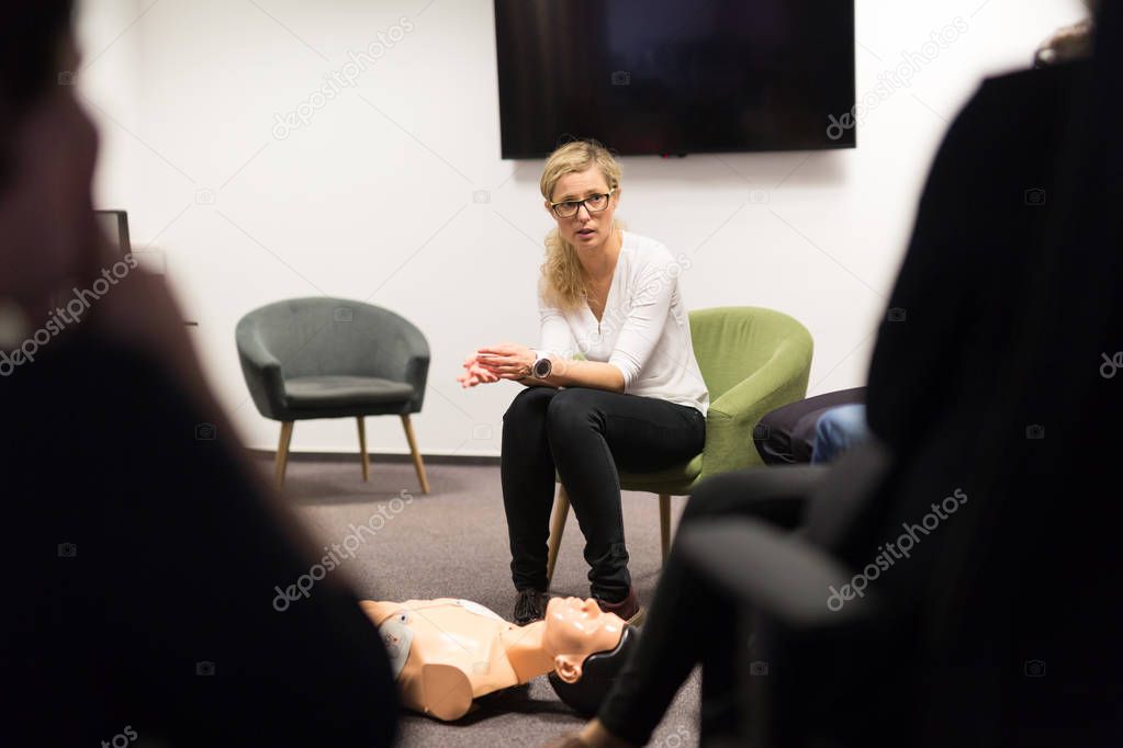 Instructor teaching first aid cardiopulmonary resuscitation course and use of automated external defibrillator on CPR workshop.