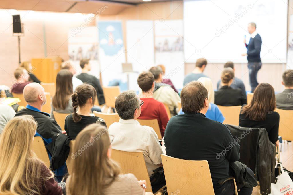 Business speaker giving a talk at business conference event.