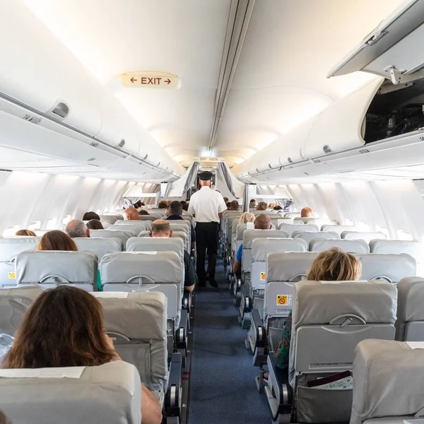 Интерьер коммерческого самолета с пассажирами на своих местах во время полета . — стоковое фото