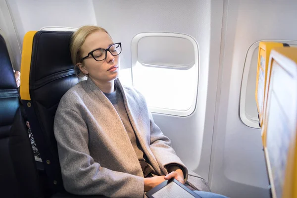 Женщина дремлет на сиденье во время путешествия на самолете . — стоковое фото