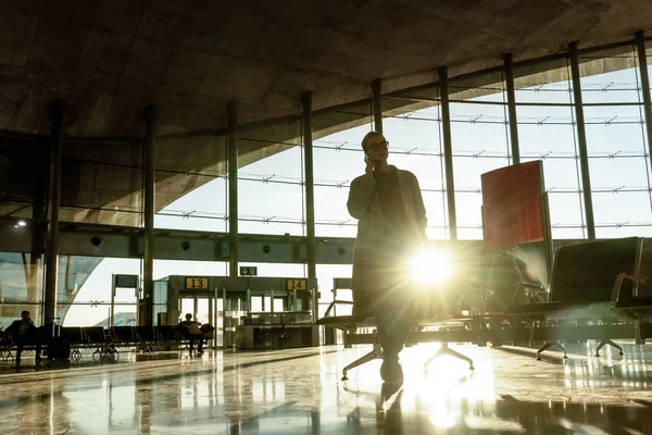 Kadın yolcunun cep telefonunu bir uçağa kalkış Havaalanı kapılarında, beklerken terminal konuşuyor. — Stok fotoğraf