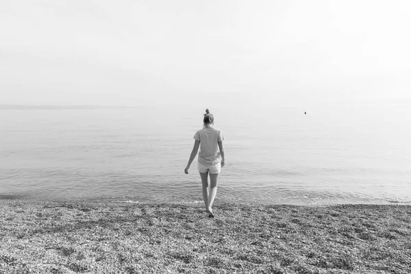 화이트 Pabbled 해변에서 일몰 산책을 즐기는 행복 한 평온한 여자. — 스톡 사진